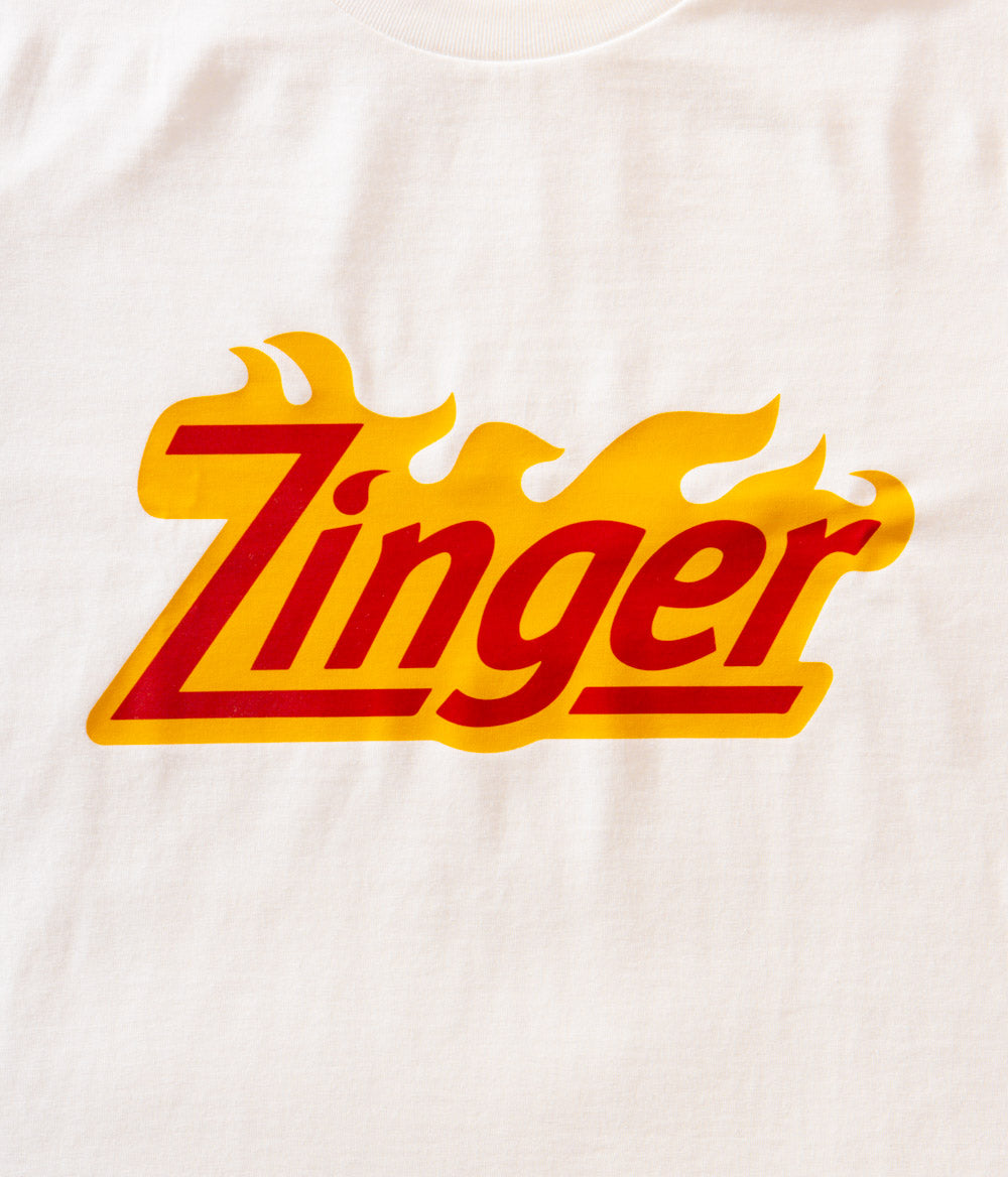 close up view of white KFC tee shirt with 'Zinger' branded logo on the front