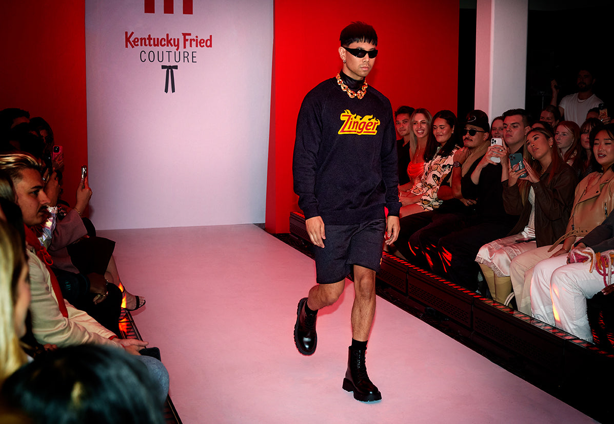 KFC model walking down a catwalk with black KFC Zinger branded jumper