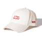 side view of KFC off-white cap with red message of 'it's finger lickin good' and KFC logo